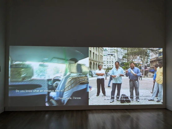 島袋道浩の映像作品。左に島袋の元の映像作品があり、その字幕の代用として、右の映像で吟遊詩人が元映像を説明(？)するように歌唱している。