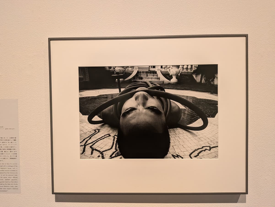 細江英公による「薔薇刑」。三島由紀夫が裸にホースを巻き付けられ横たわっている。写真は三島の頭部側から撮影している。