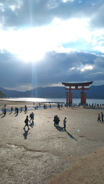 厳島神社の鳥居の写真。大きな鳥居の周りにちっこい人たち。